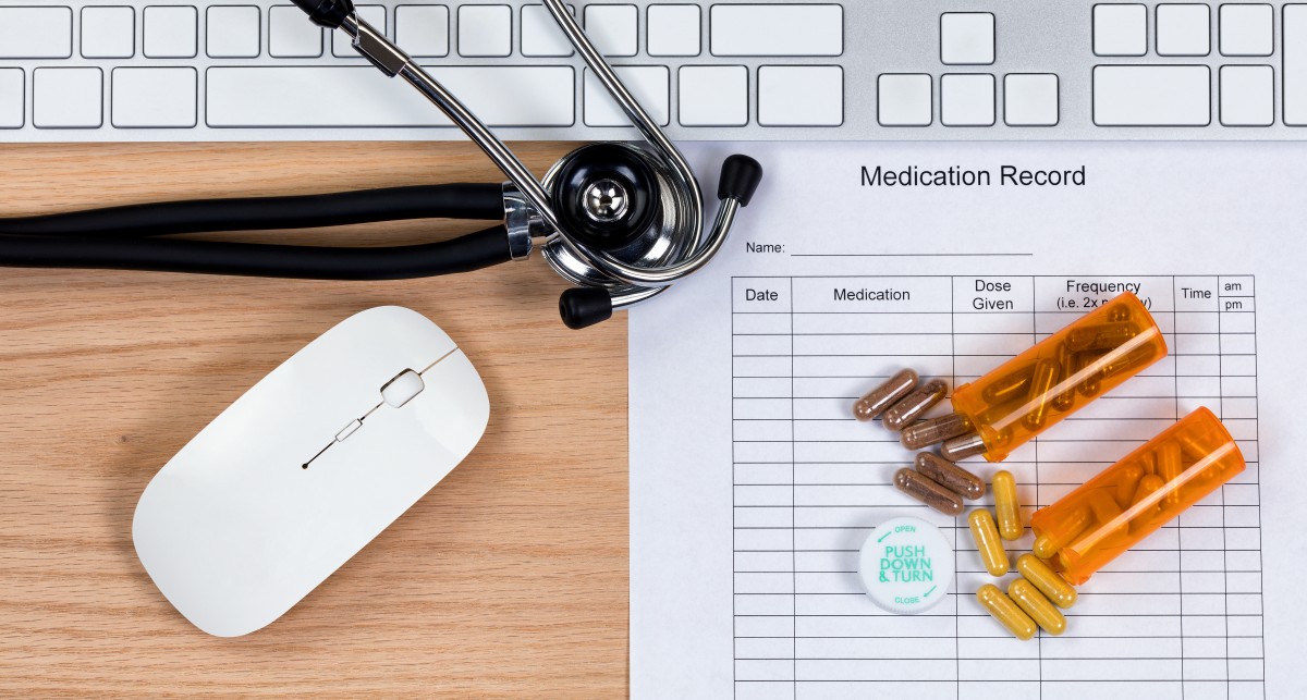 computer, stethoscope, prescription and medication record on a desk100303810