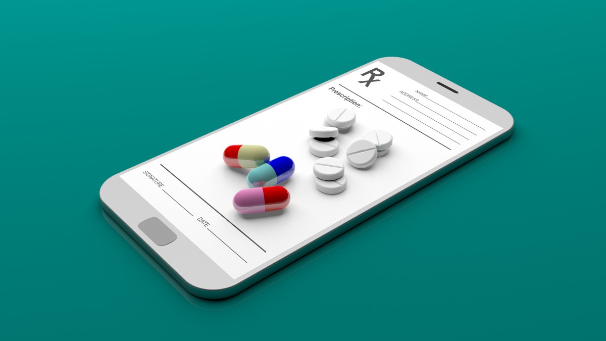 Prescription pills sit on phone/tablet with prescription notations 165140669