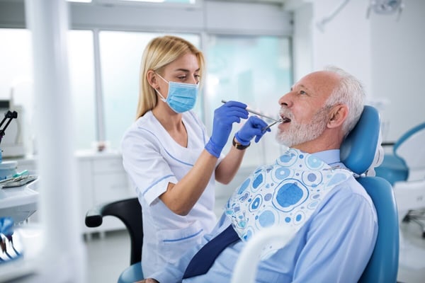 dental hygienist cleans a patient's teeth  194285663