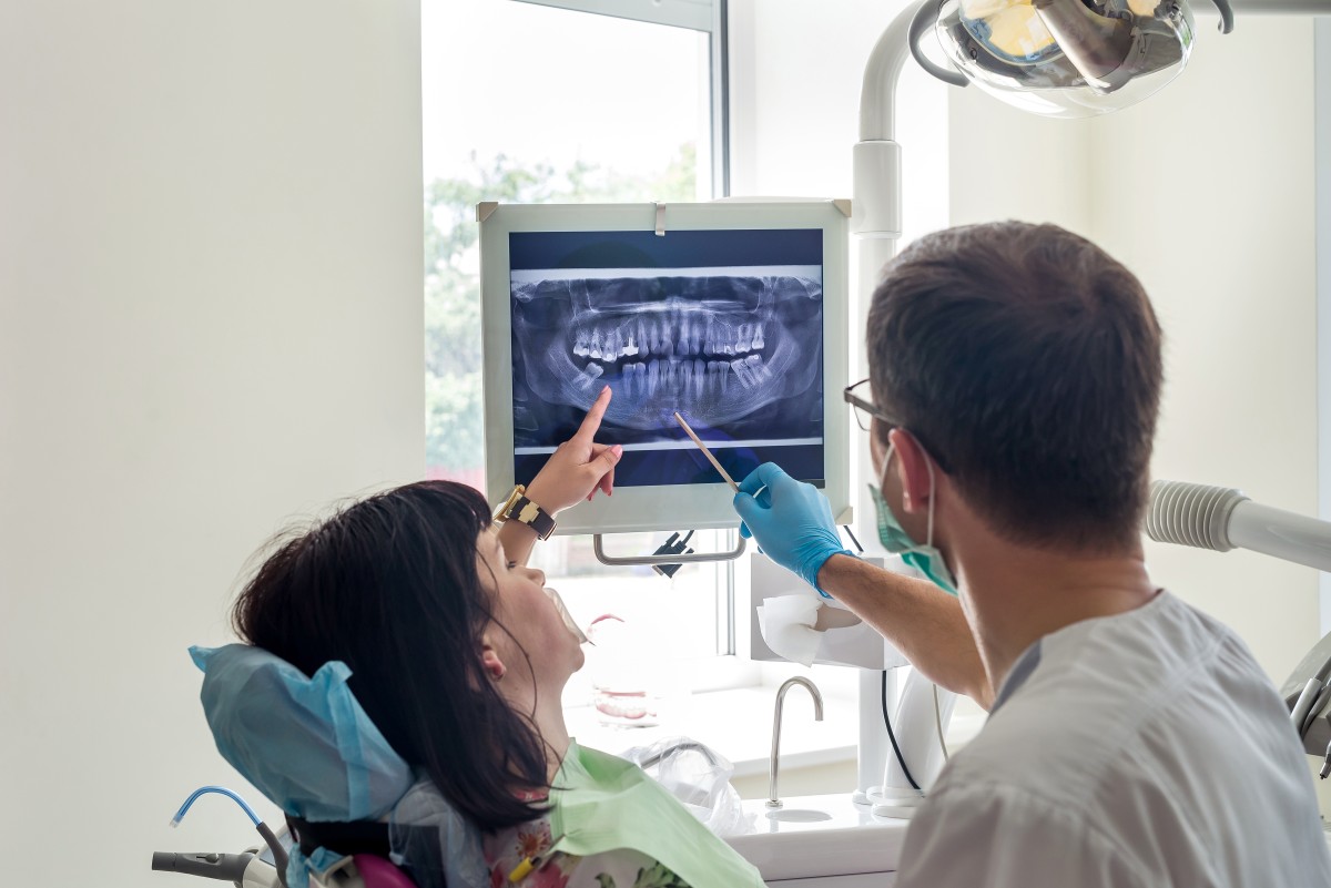 Dentist shows patient xray in exam room 225633975