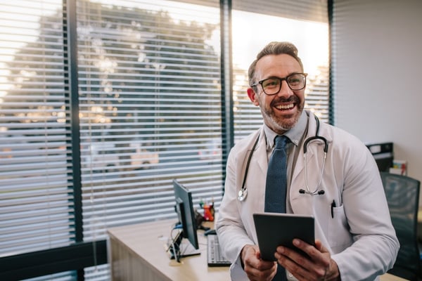Smiling doctor with tablet in hand 246365778