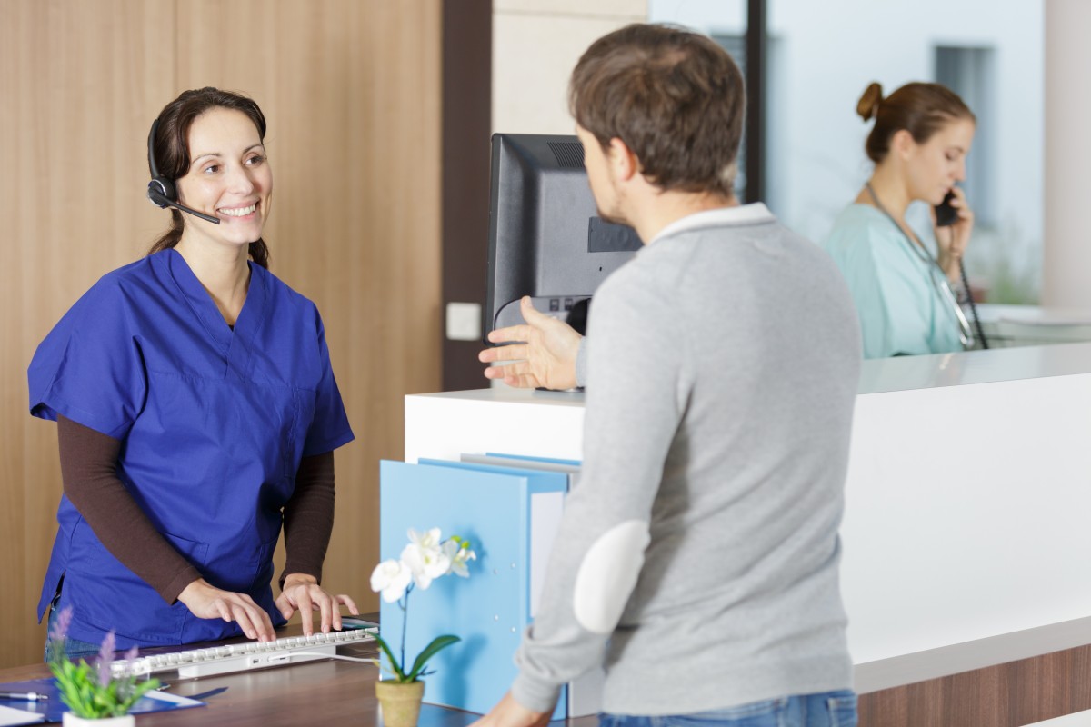 receptionist smiles at patient insurance verification 269092471