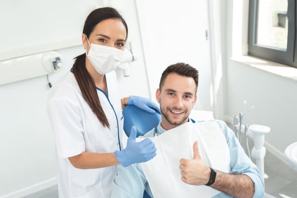 Patient and dentist give thumbs up in exam room 279996348