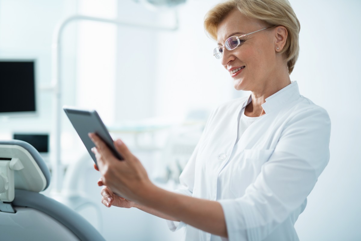 Dentist uses tablet to ePrescribe for a patient 289831730