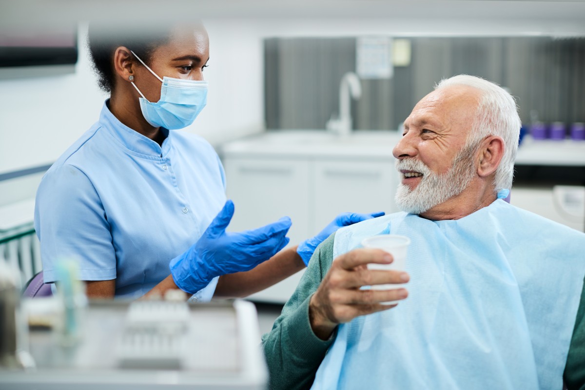 Smiliing older patient and dental tech at dental appointment 428090157