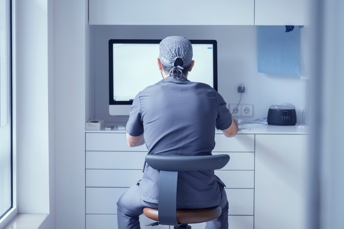 Dentist sits in front of computer screen 431353808