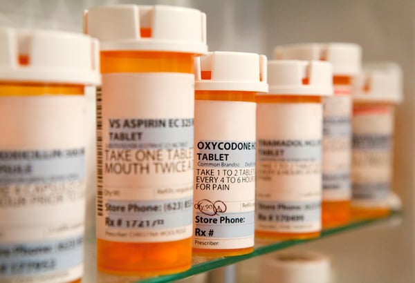 prescription bottles lined up on a shelf 48125229