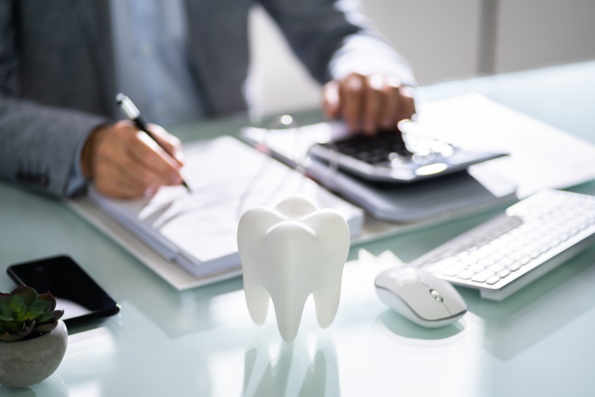 man at desk using calculator for dental billing and claims 521594603