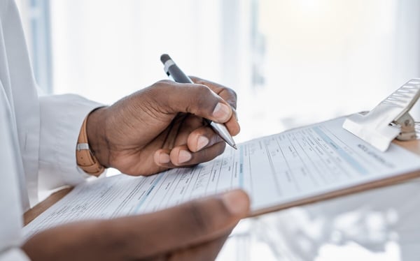 healthcare provider writes on paper on a clipboard 524754496