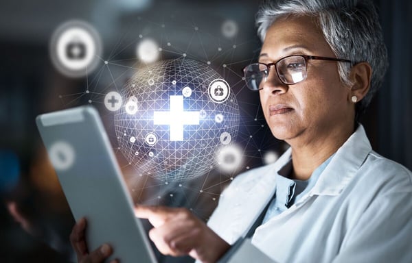 Female healthcare provider looks at tablet with a projected inamge of security and healthcare data565564927