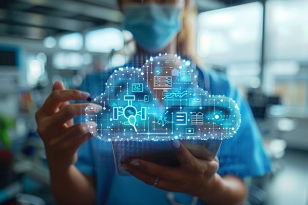 Woman in scrubs and mask holding a tablet computer with translucent cloud demonstrating healthcare connectivity 800939512