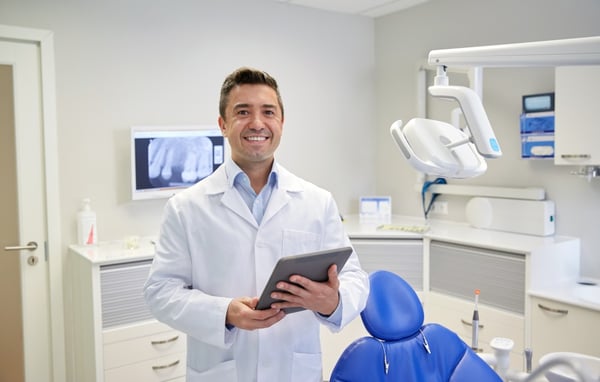 Smiling dentist with tablet for eprescriptions 88682002