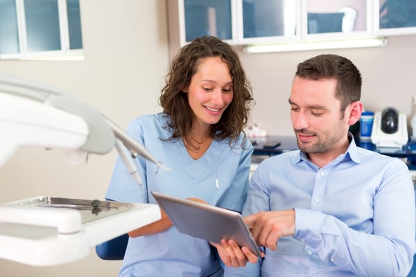 dental patient reviewing patient education videos on a tablet