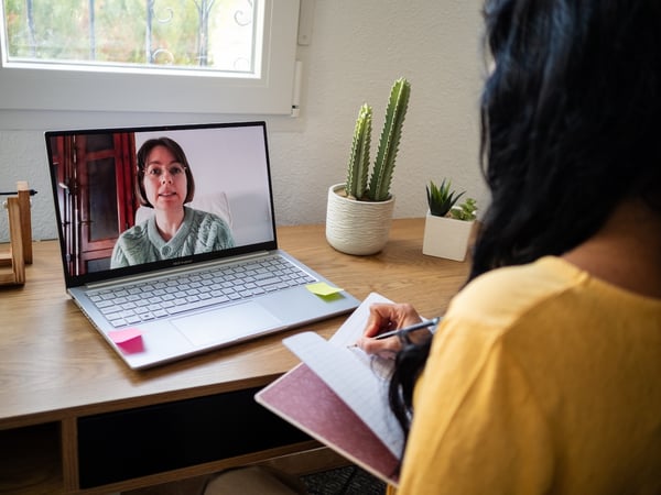 pateint taking notes from educaitonal video at home
